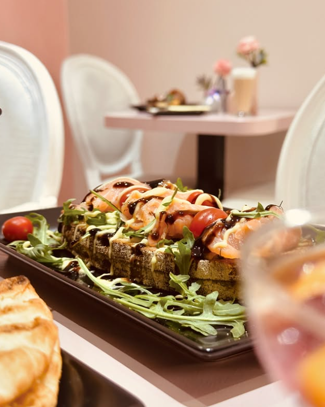 Lachs-Stulle mit Rucola, Cherrytomaten und Balsamico auf schwarzer Platte